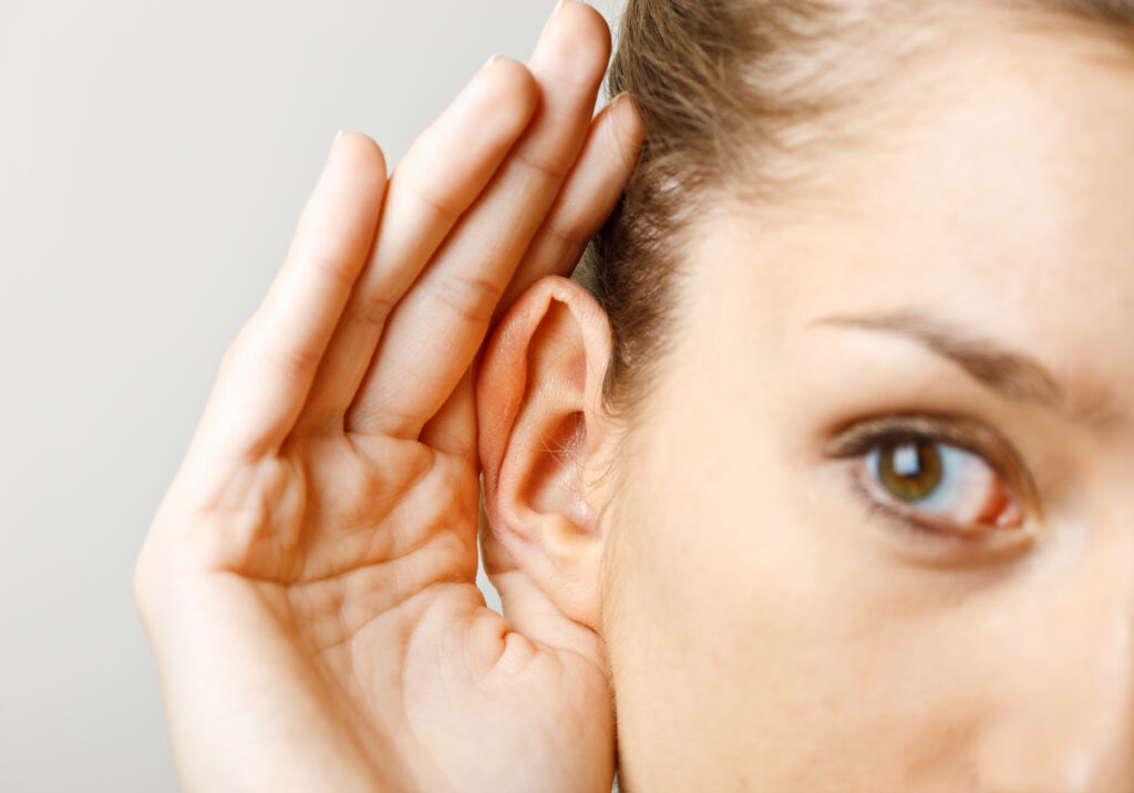 A woman with her hand by her ear