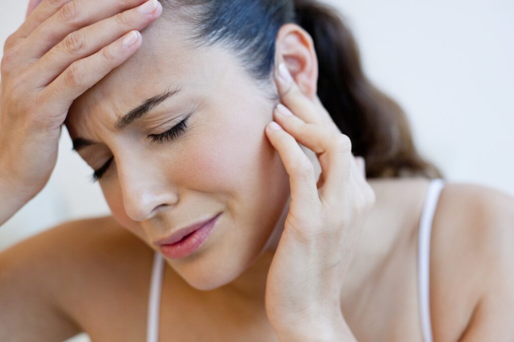 Woman touching her head and ear with earache.