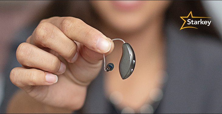 Woman in background holding a Starkey hearing aid